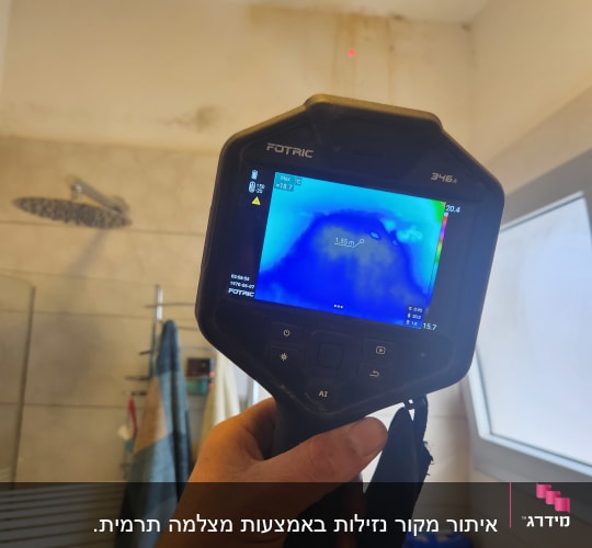 מכשיר תרמי בודק נזילות על קיר חדר אמבטיה